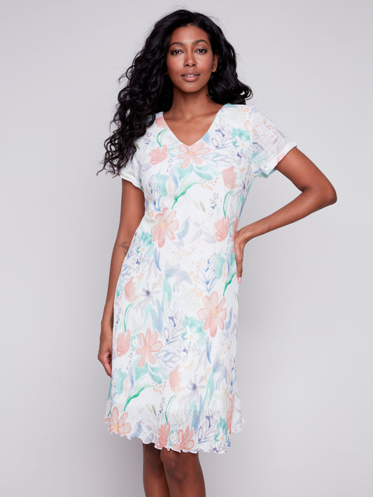 Woman posing in a comfortable Charlie B cotton floral print dress against a grey background.
