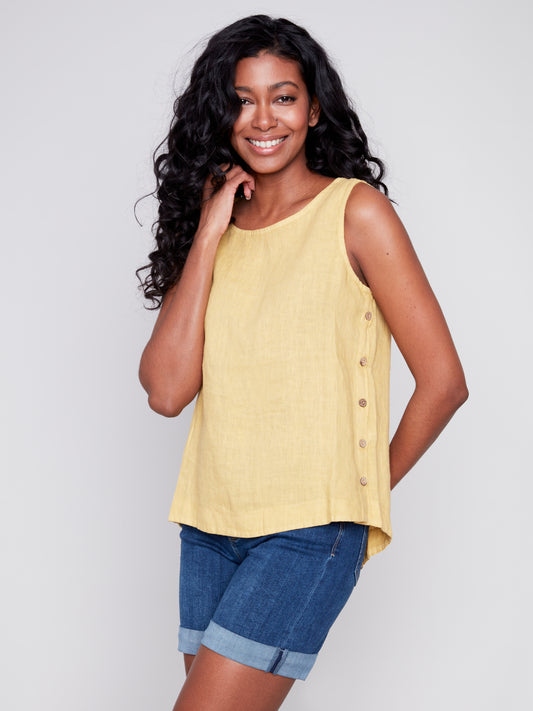 Description: A woman wearing a Charlie B Sleeveless Linen Blouse with Side Button Detail.