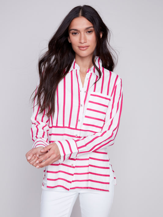 Woman wearing a Charlie B Lined Blend Striped 3/4 Button Top with white pants posing against a gray background.