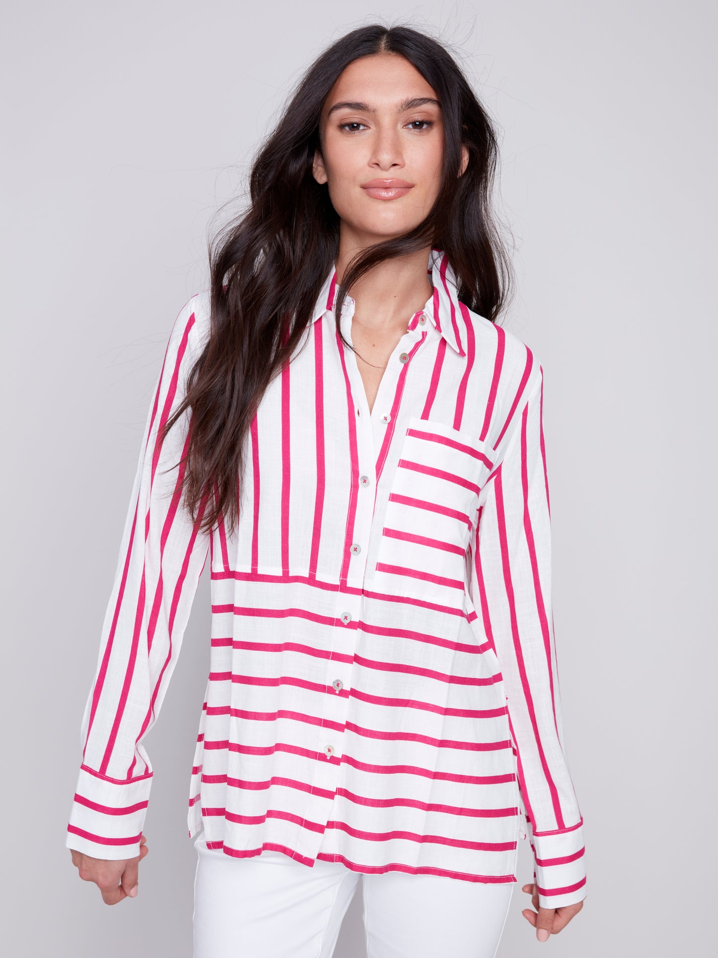Woman wearing a Charlie B Lined Blend Striped 3/4 Button Top with white pants posing against a gray background.