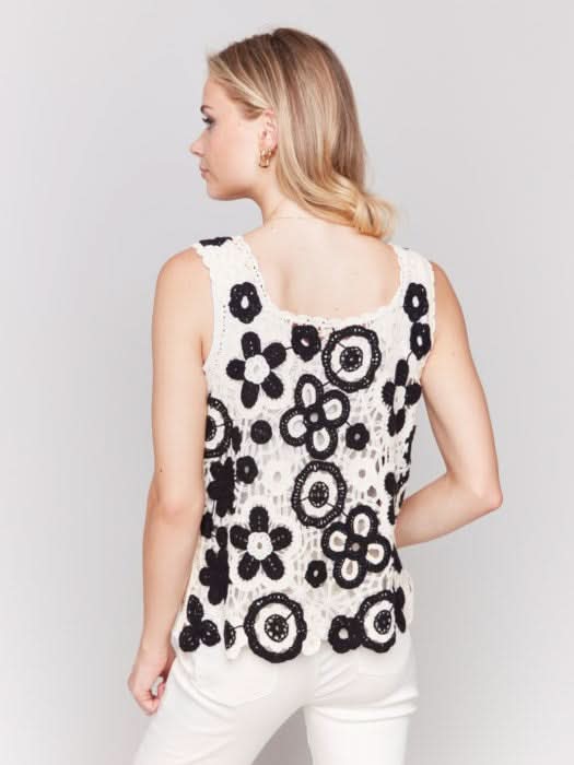 A woman wearing the Charlie B Contrast Floral Crochet Sleeveless Top with a square neck stands against a plain background.