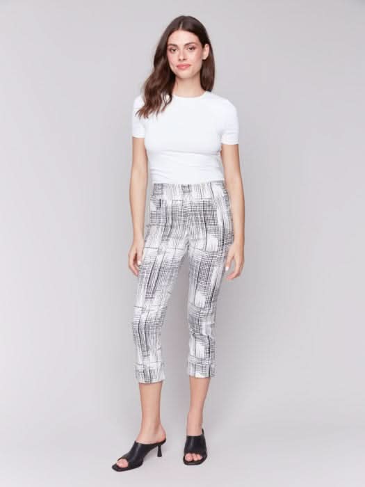 A person is wearing Charlie B's Printed Stretch Pull-On Capri Pants in black and white, offering a flattering fit. Paired with a white top and black open-toed heels, they stand against a plain background, exuding ultimate comfort for any occasion.