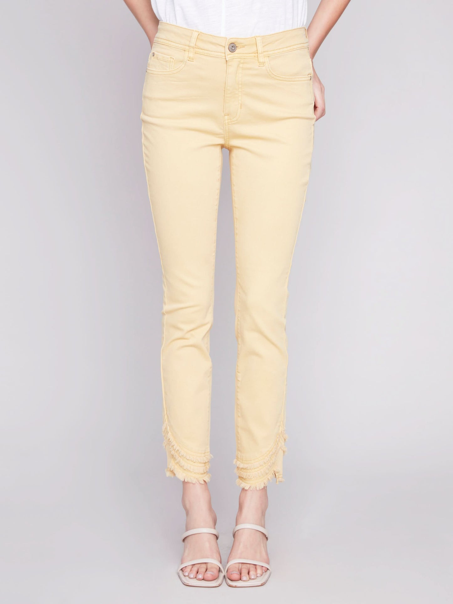 The model is wearing a cute and stylish design, combining a white t-shirt with Charlie B's Slant Fringe Ankle Pant.