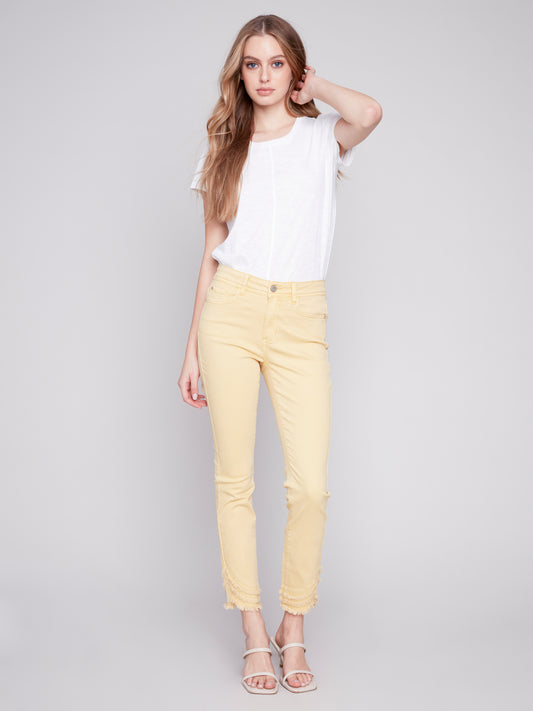 The model is wearing a cute and stylish design, combining a white t-shirt with Charlie B's Slant Fringe Ankle Pant.