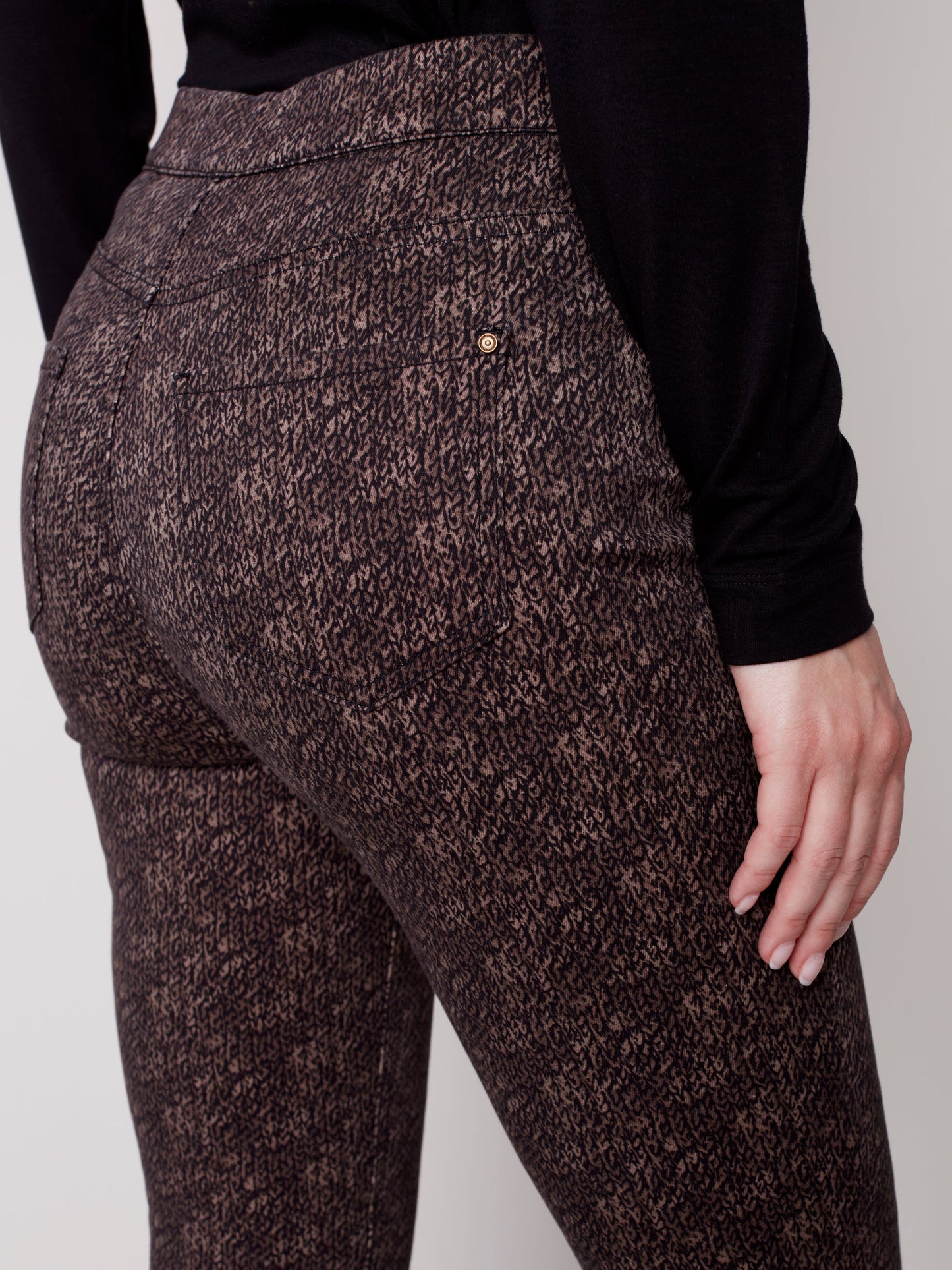 The model is wearing a black turtleneck and brown Charlie B Printed Twill Pull On Pant.