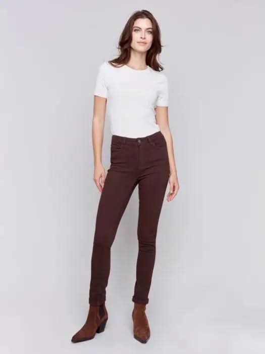 A person wearing Charlie B's brown Cuffed Hem Twill Jeans, a white top, and brown ankle boots stands against a plain background, showcasing the slimming effect and quality materials of the outfit.