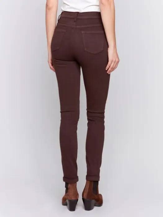 A person wearing Charlie B's brown Cuffed Hem Twill Jeans, a white top, and brown ankle boots stands against a plain background, showcasing the slimming effect and quality materials of the outfit.
