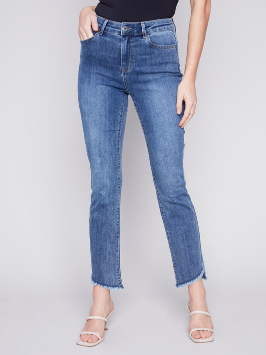 A woman donning a must-have pair of Charlie B Asymmetrical Boot Cut Hem Jeans.