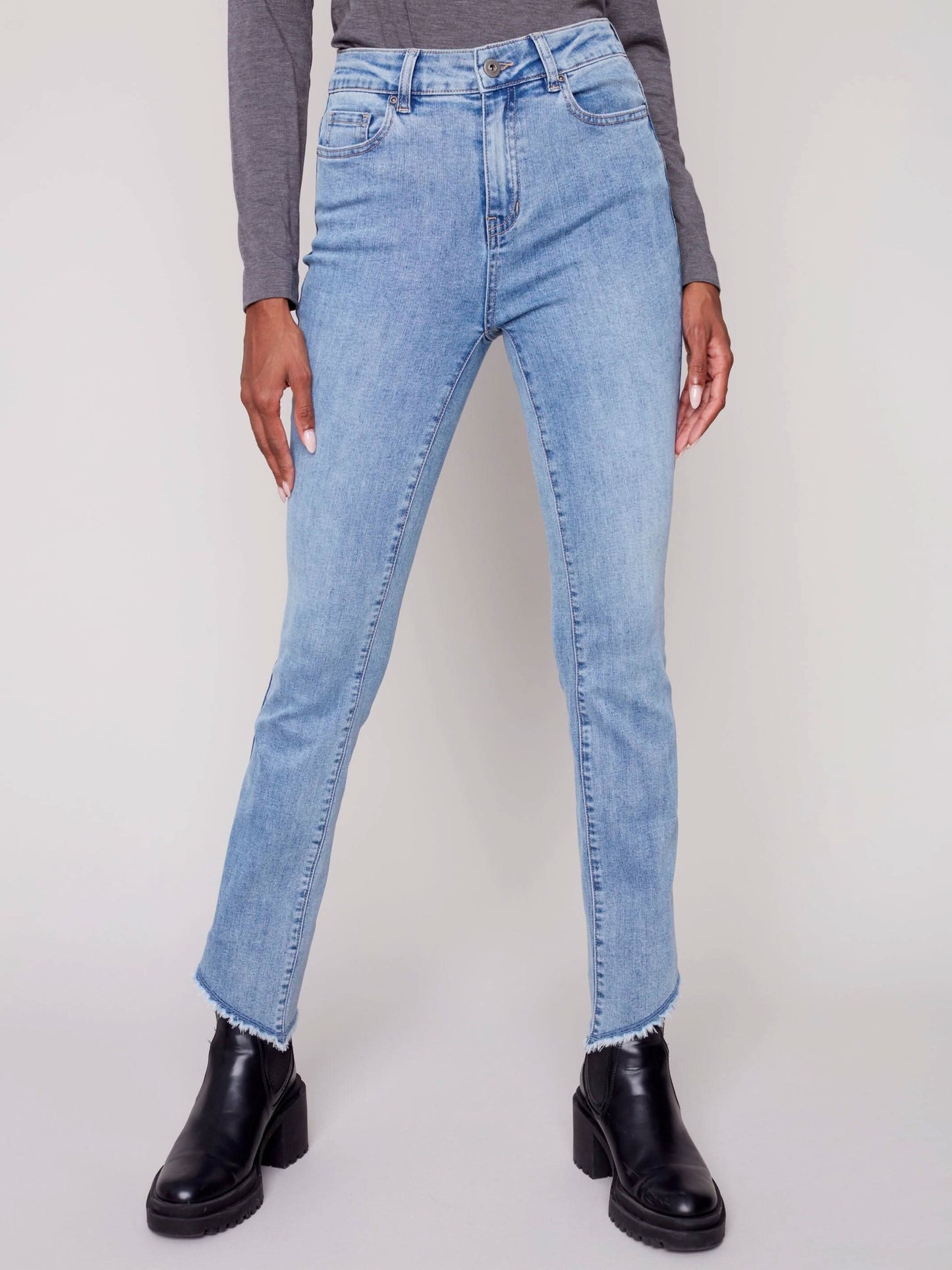 A woman in Charlie B's asymmetrical hem bootcut jeans and black Chelsea boots creates a flattering look.