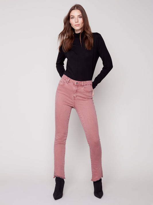 A woman in Charlie B's asymmetrical hem bootcut jeans and black Chelsea boots creates a flattering look.
