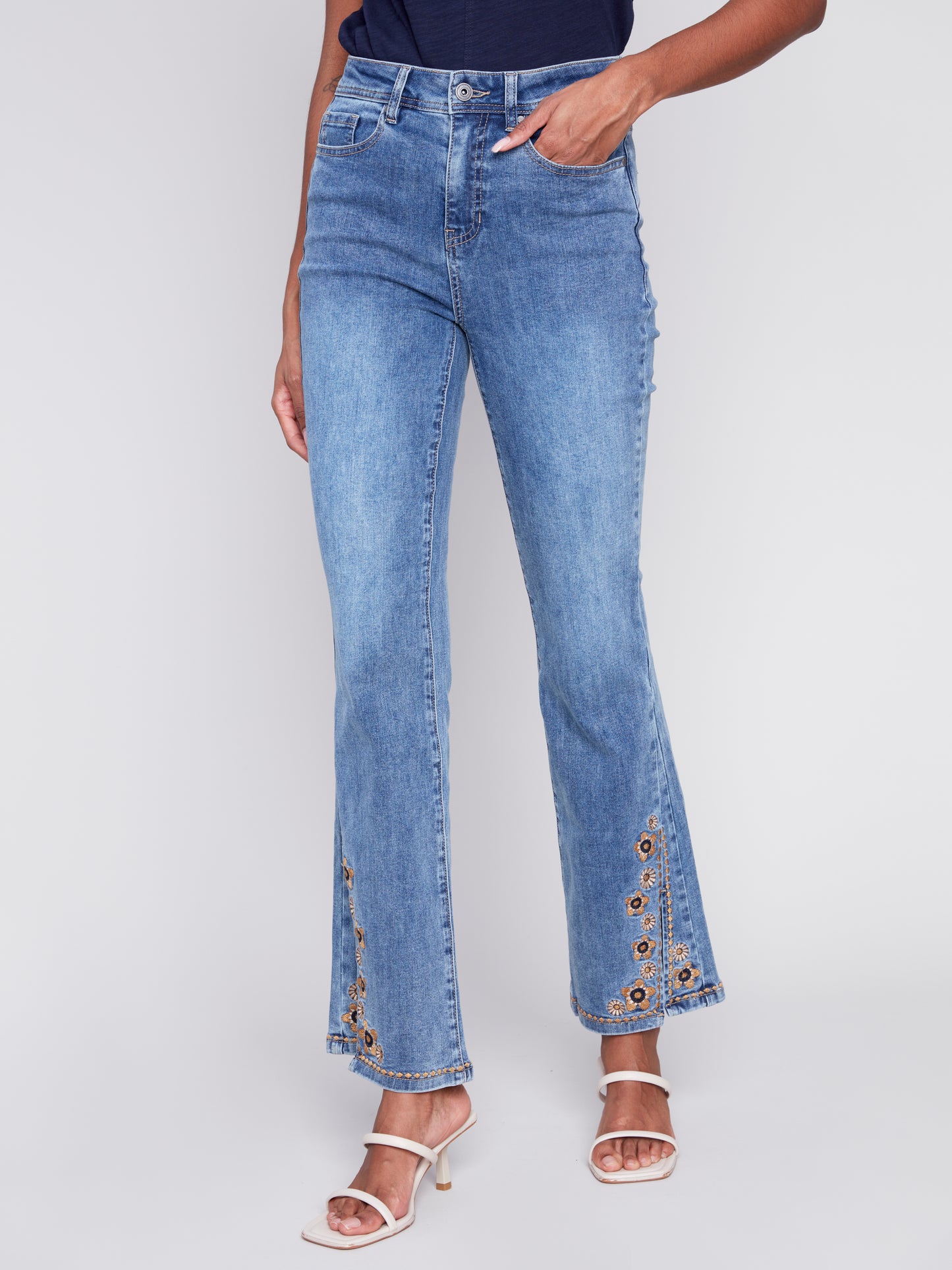 A woman exuding retro vibes in a pair of Charlie B's Slit Bell Bottom Jeans with Embroidered Slits.