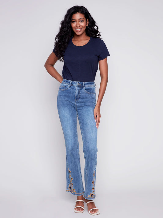 A woman exuding retro vibes in a pair of Charlie B's Slit Bell Bottom Jeans with Embroidered Slits.