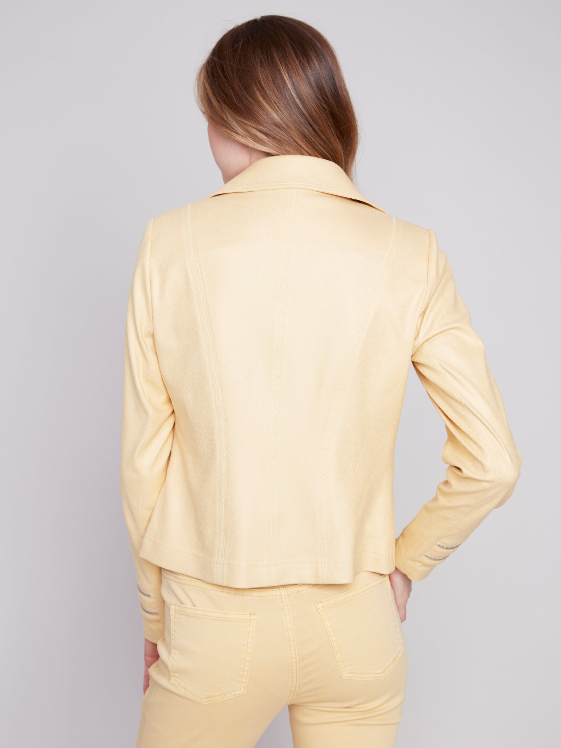 A woman wearing a yellow Charlie B Vintage Moto Faux Leather Jacket.