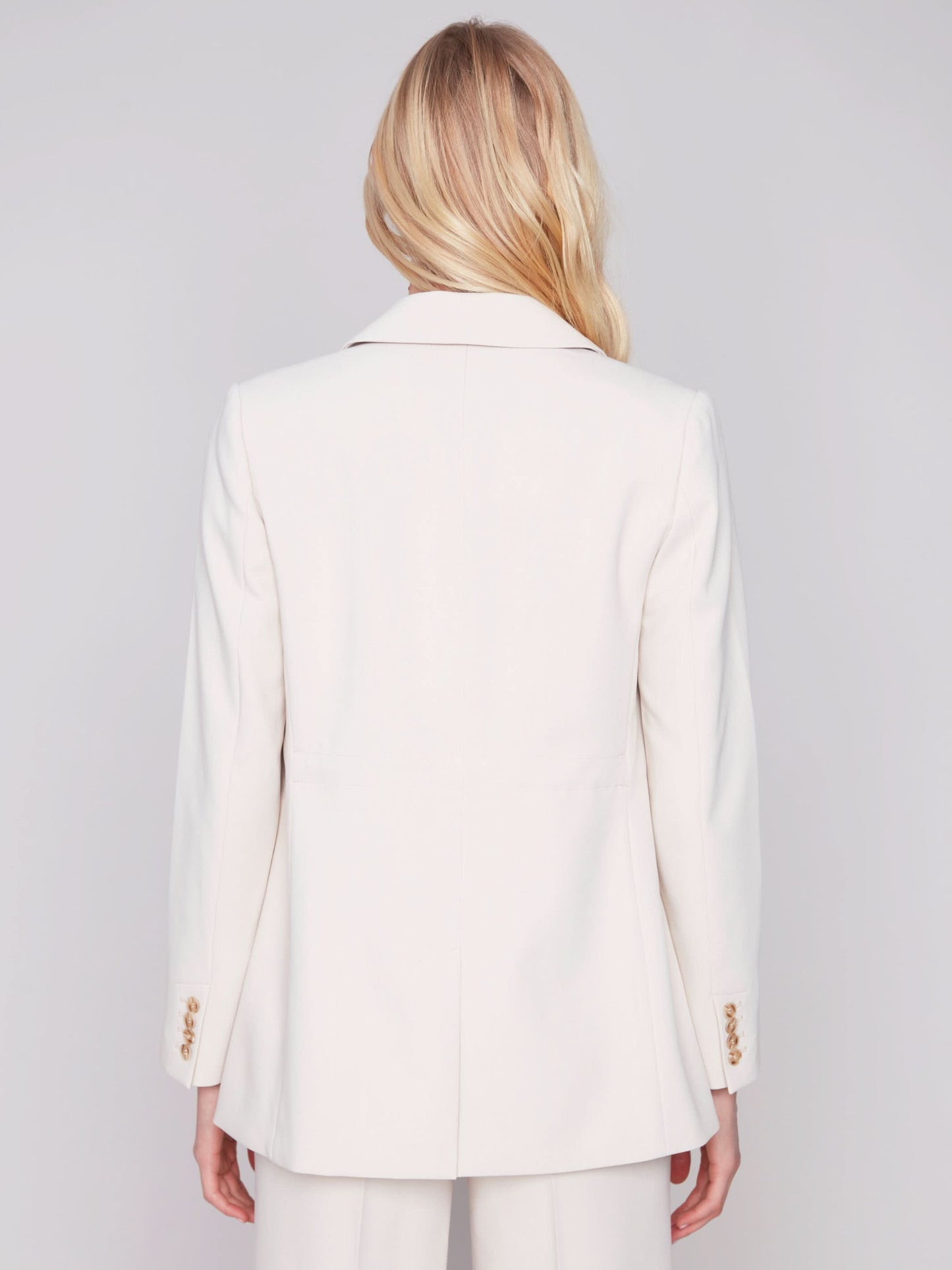 The model is wearing a Charlie B beige blazer with Rushed Back and pants made from quality fabric.