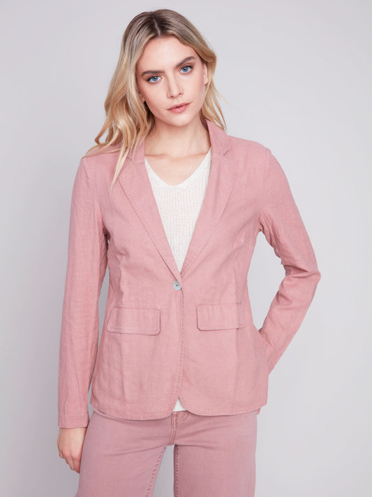 The model is wearing a pink Charlie B lined button-up blazer, a wardrobe staple that is made with high-quality materials.