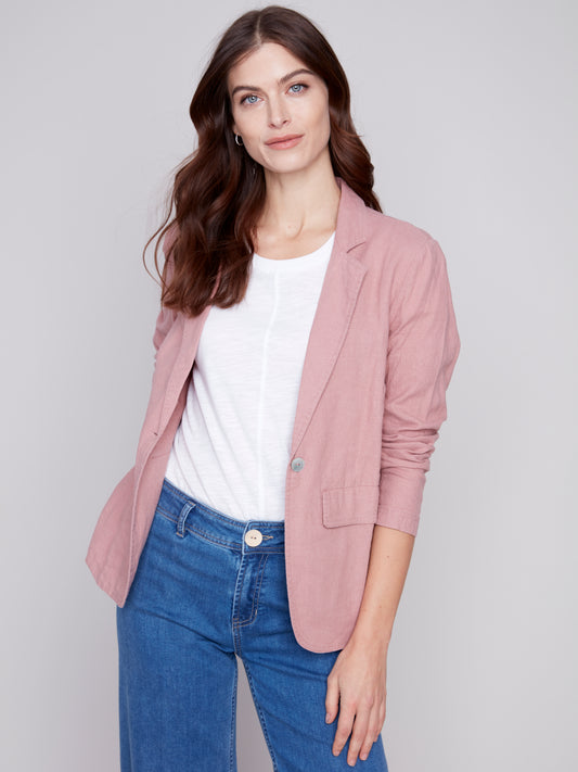 The model is wearing a pink Charlie B lined button-up blazer, a wardrobe staple that is made with high-quality materials.