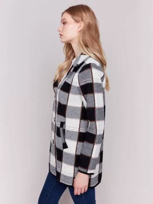 A woman with long hair, standing against a plain background and showcasing her winter wardrobe, is wearing the Charlie B Knit Plaid Coat along with jeans.