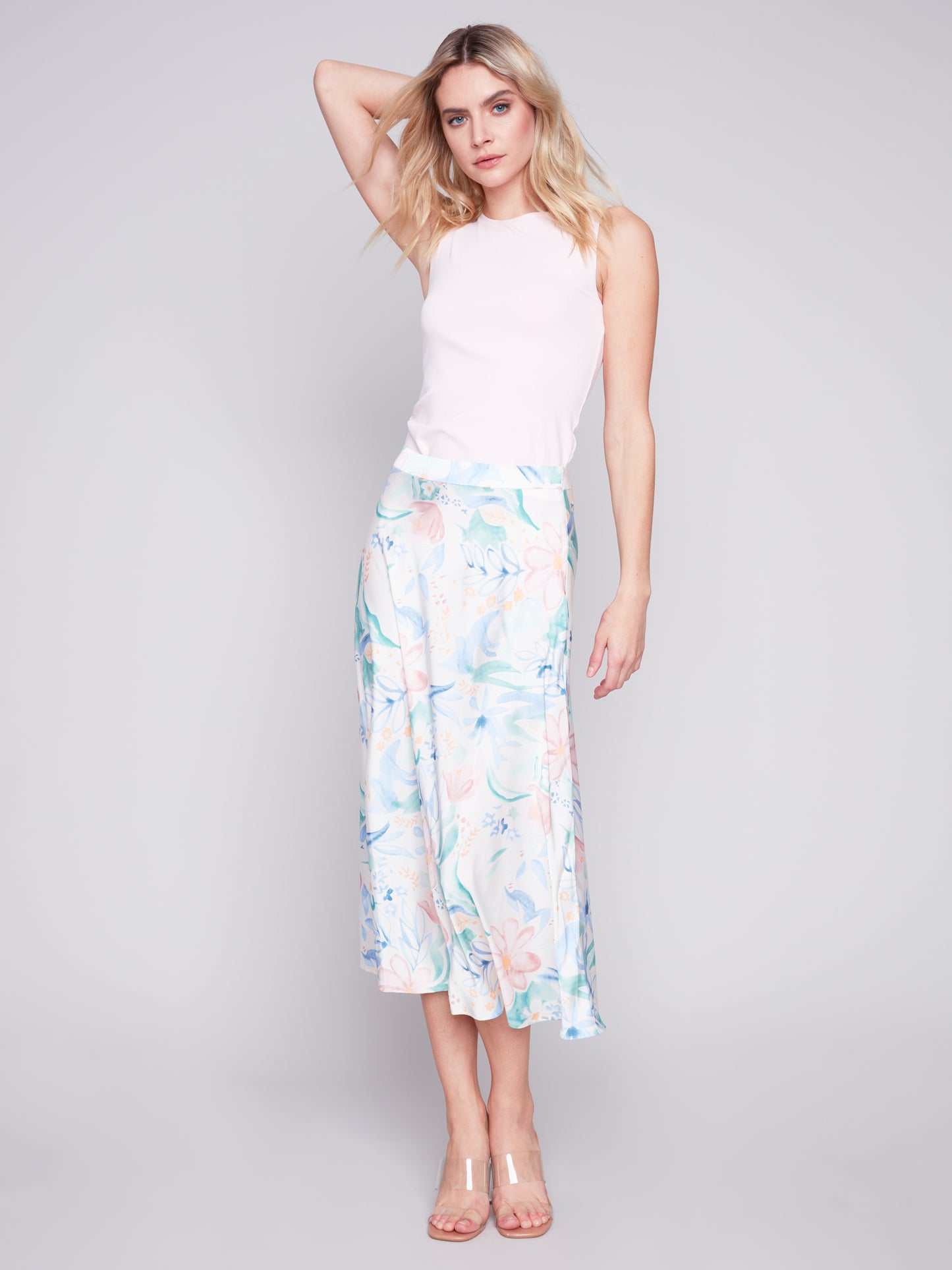 Woman posing in a sleeveless top and Charlie B Petal Flow Long Satin Skirt.