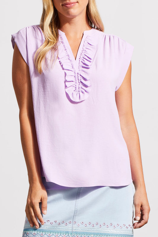Woman wearing a stylish, light purple Tribal cap sleeve blouse with frill details around the v-neckline.