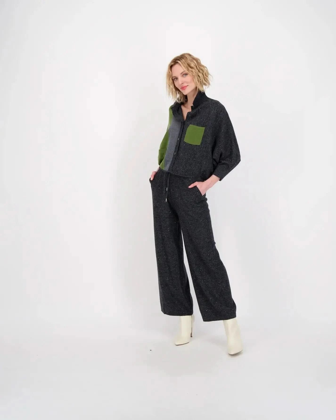 A woman wearing a grey jumpsuit and green boots made of stretchy knit fabric, Gabby Isabella's Color Block Knit Sweater Pullover Top.