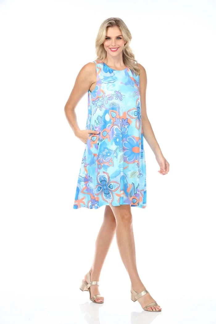 Standing against a white background, the person wears Tango Mango's Round Neck Floral Sleeveless Dress, featuring a blue and orange design with handy pockets.