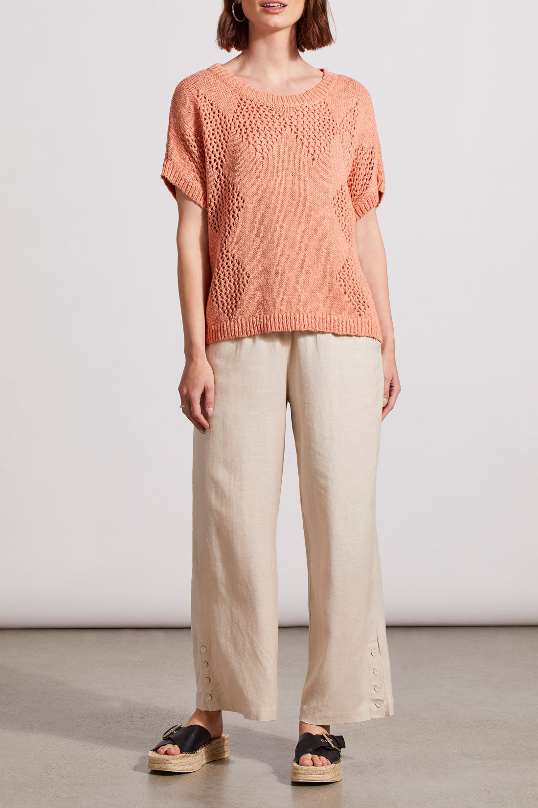 Woman wearing a stylish coral Dolman Short Sleeve Crochet Sweater by Tribal with a layering patterned design.