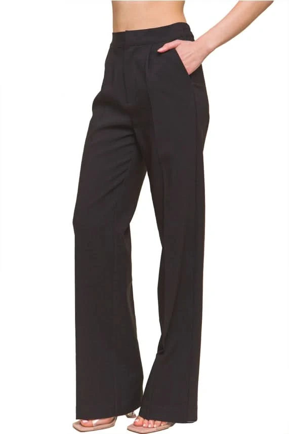 A person wearing Vanilla Monkey Dress Pant with Elastic Back in bright green and black pointed-toe shoes. The background is plain white.