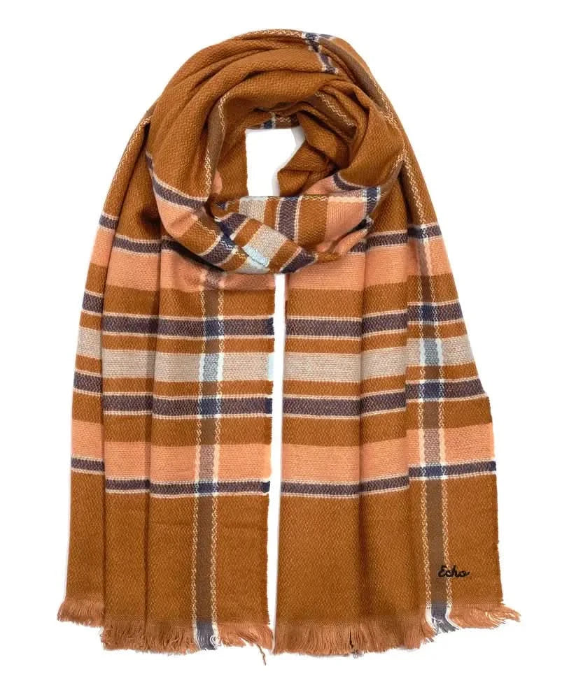 A woman wearing an Echo New York Campfire Plaid Scarf measuring 22" X 76".