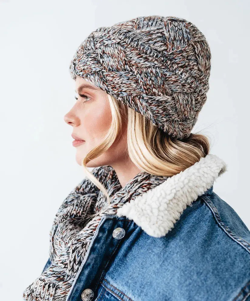 A woman wearing a lightweight denim jacket and an Echo New York Marled Basetweave Toque for cold weather.