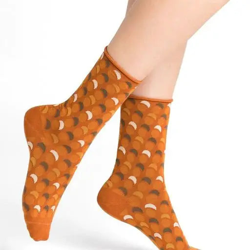 A woman's legs with orange and brown patterned 6362 socks from Bleuforet, made of 97% cotton and available in one size.