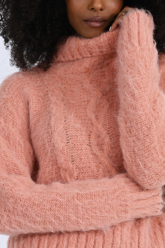 A woman wearing a timeless pink Molly Bracken Turtleneck Cable Knit Sweater.