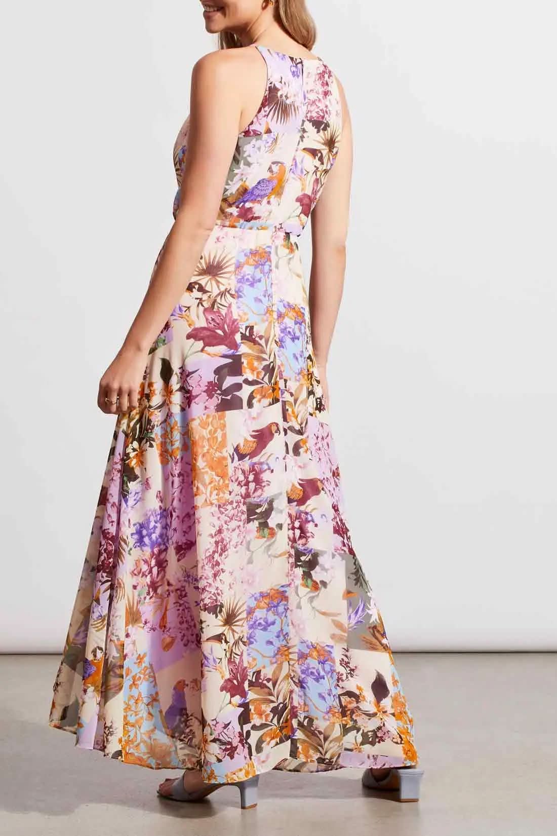 A woman wearing a flowing, floral Tribal maxi dress with halter neckline, posing in a studio setting.