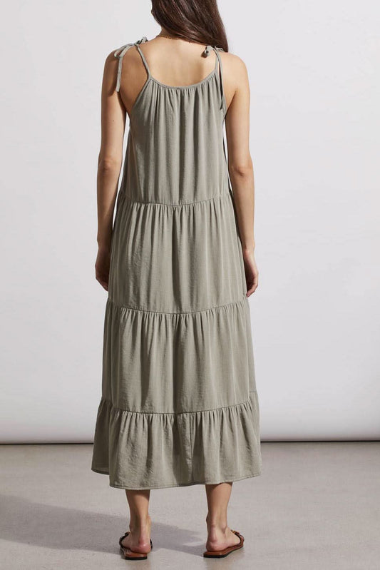 A woman standing in a neutral pose wearing a Tribal lined sleeveless dress with adjustable straps and brown sandals.