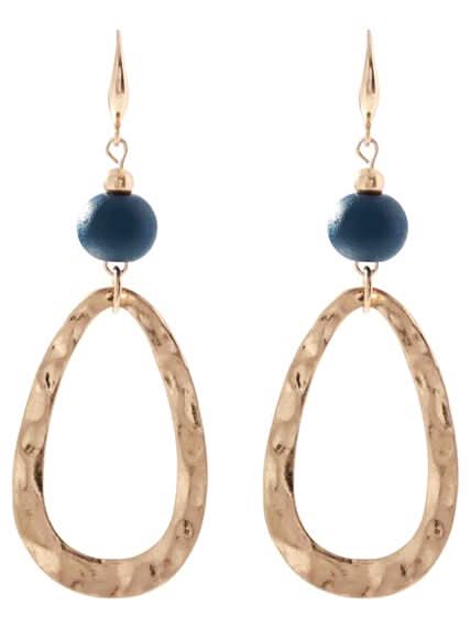The Merx Natural Stone Set Earring features hammered gold-plated teardrop shapes with round navy blue stone beads, elegantly hanging from gold hooks.