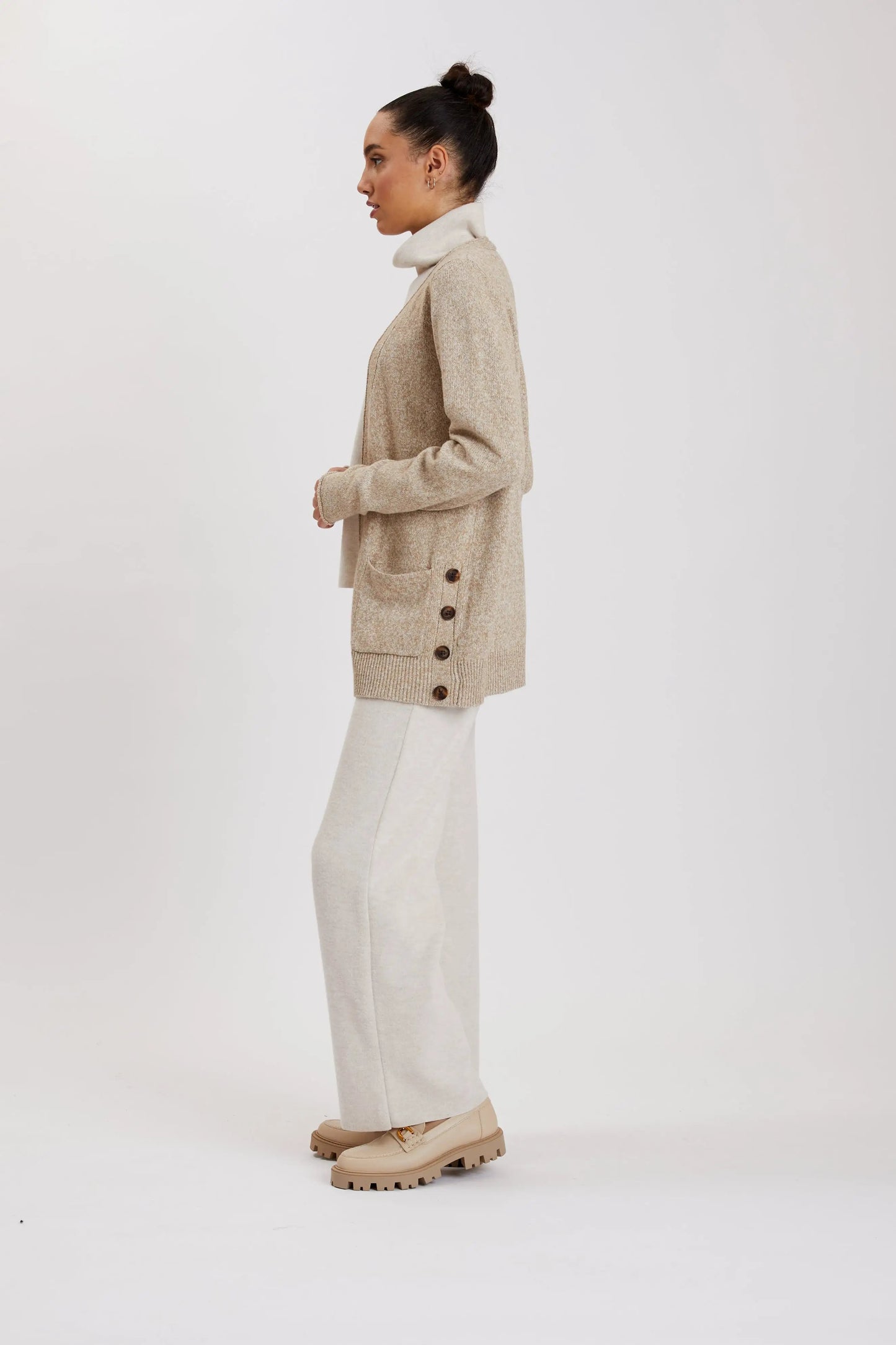 A woman wearing a Point Zero MOL9199 cardigan in beige, featuring side buttons and made from soft fabric, seen from the back.