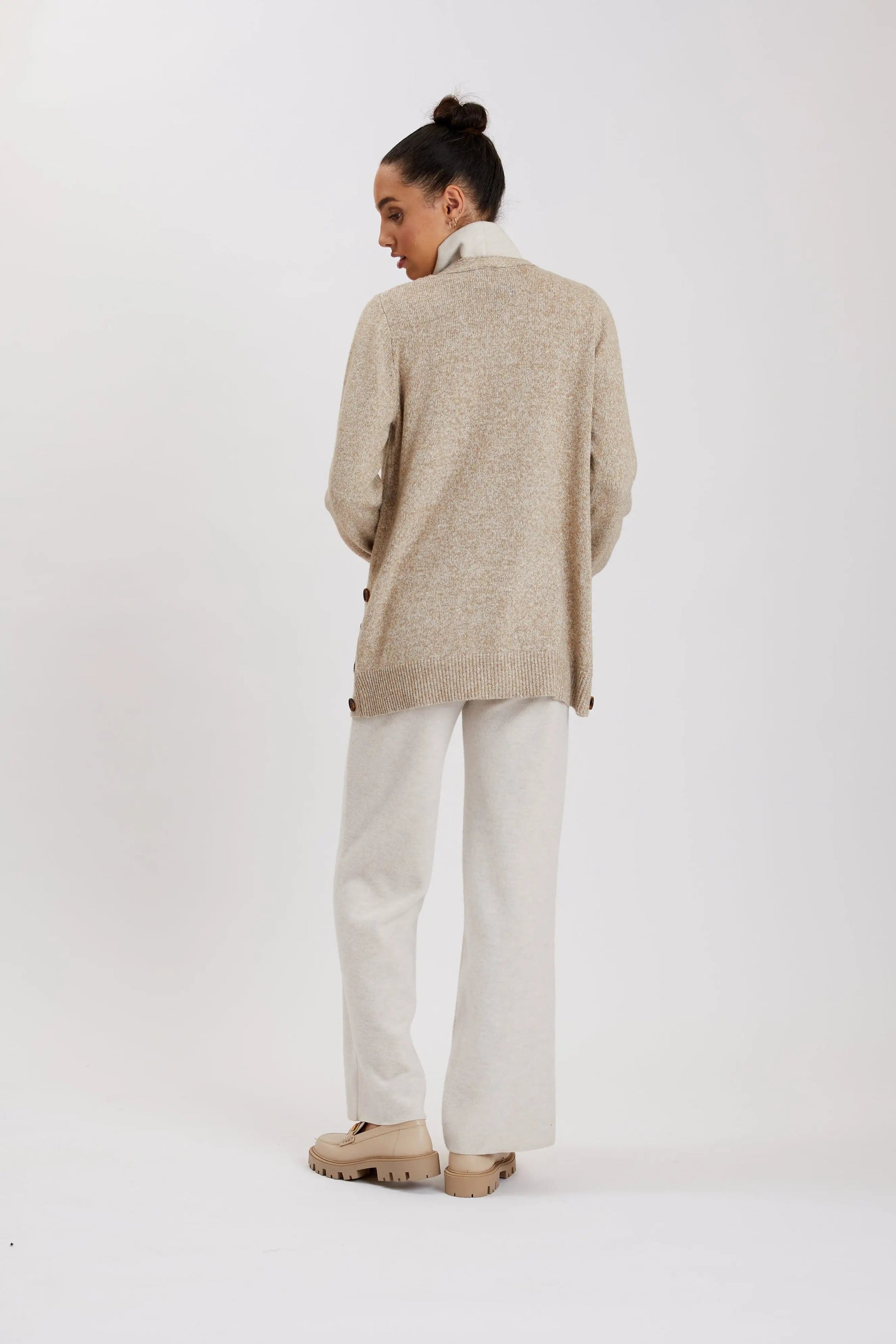 A woman wearing a Point Zero MOL9199 cardigan in beige, featuring side buttons and made from soft fabric, seen from the back.