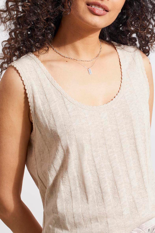 A woman wearing a comfortable Tribal knit material tank top with picot edge trim and a delicate necklace with a rectangular pendant.