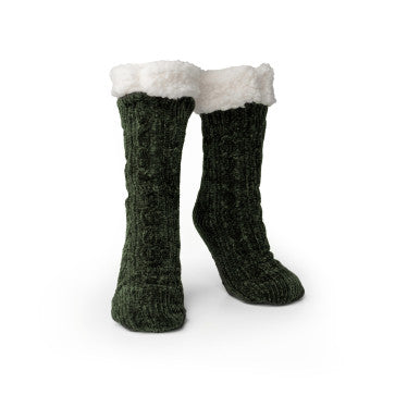 A woman sitting on a chair wearing Cray Cray Soft Slipper Socks, the slip-proof chenille fuzzy socks from Britt's Knits.