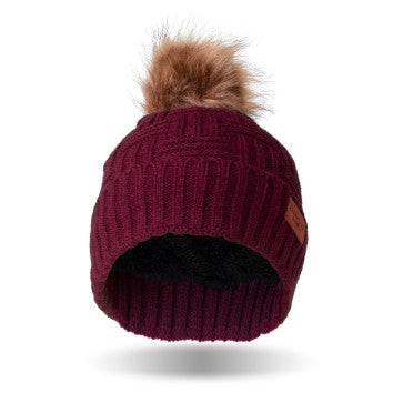 A woman wearing a Britt's Knits Classic Pom Hat in cold weather.