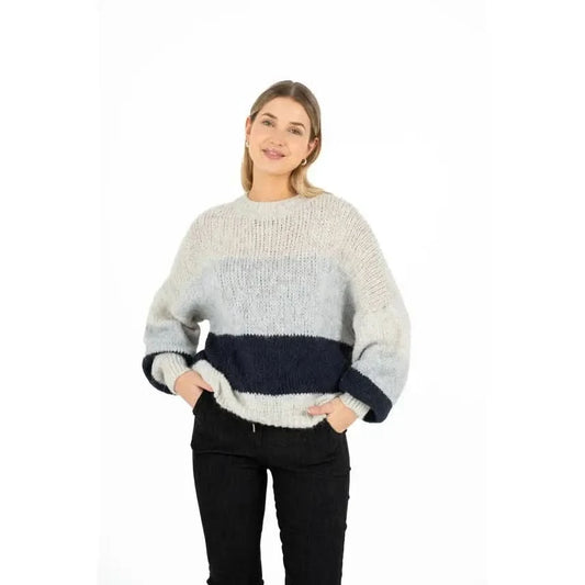 A person is wearing the M Made In Italy Oversized Colorblock Knit Sweater, featuring sections of light and dark gray, and standing against a plain white background.