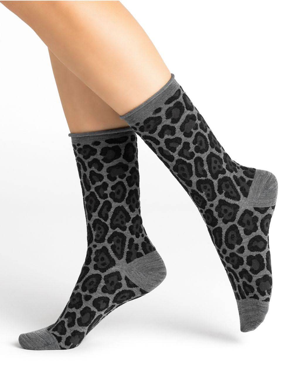 A woman's legs with Bleuforet black and grey leopard print merino wool socks.