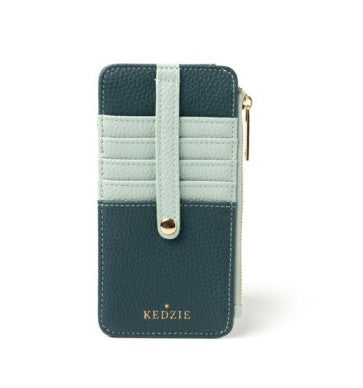 A woman sitting on a bench with a blue Kedzie Slim Zippered Wallet that has card slots.