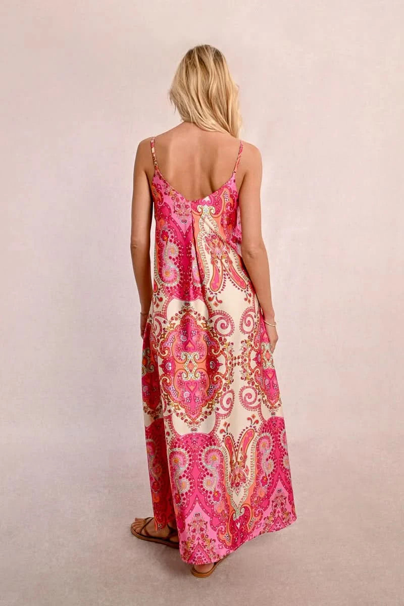 Against a plain light background, an elegant person with long hair is seen wearing a Satin Dress With Straps by Molly Bracken, along with brown sandals.