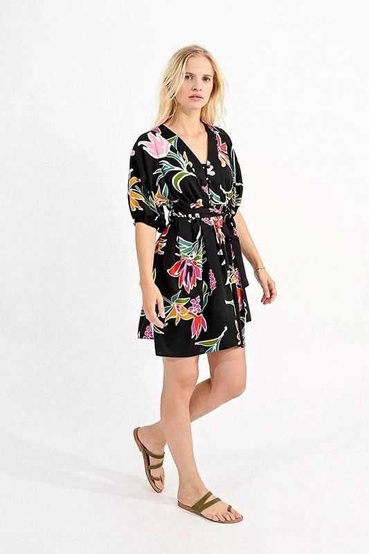 Woman wearing a Molly Bracken belted mini shirt dress with a floral print, ideal for a summer wardrobe.
