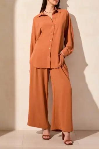 A person wearing the Tribal FLOWY RAGLAN SLEEVE SHIRT in brown, paired with loose-fitting pants, stands against a plain light-colored background.