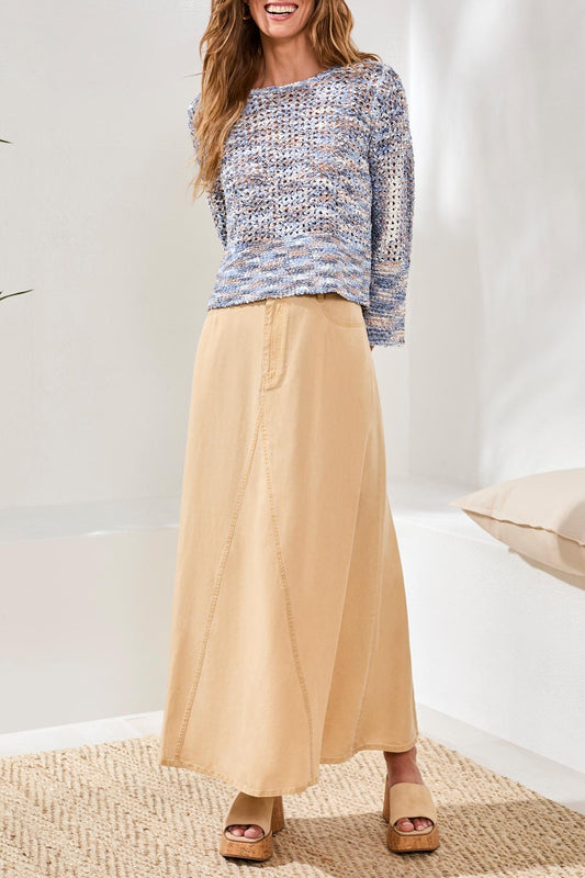 A woman wears the Tribal Bell Sleeve Sweater—an open stitch, long-sleeve blue and beige top—paired with a high-waisted beige skirt, shown from shoulders to knees.