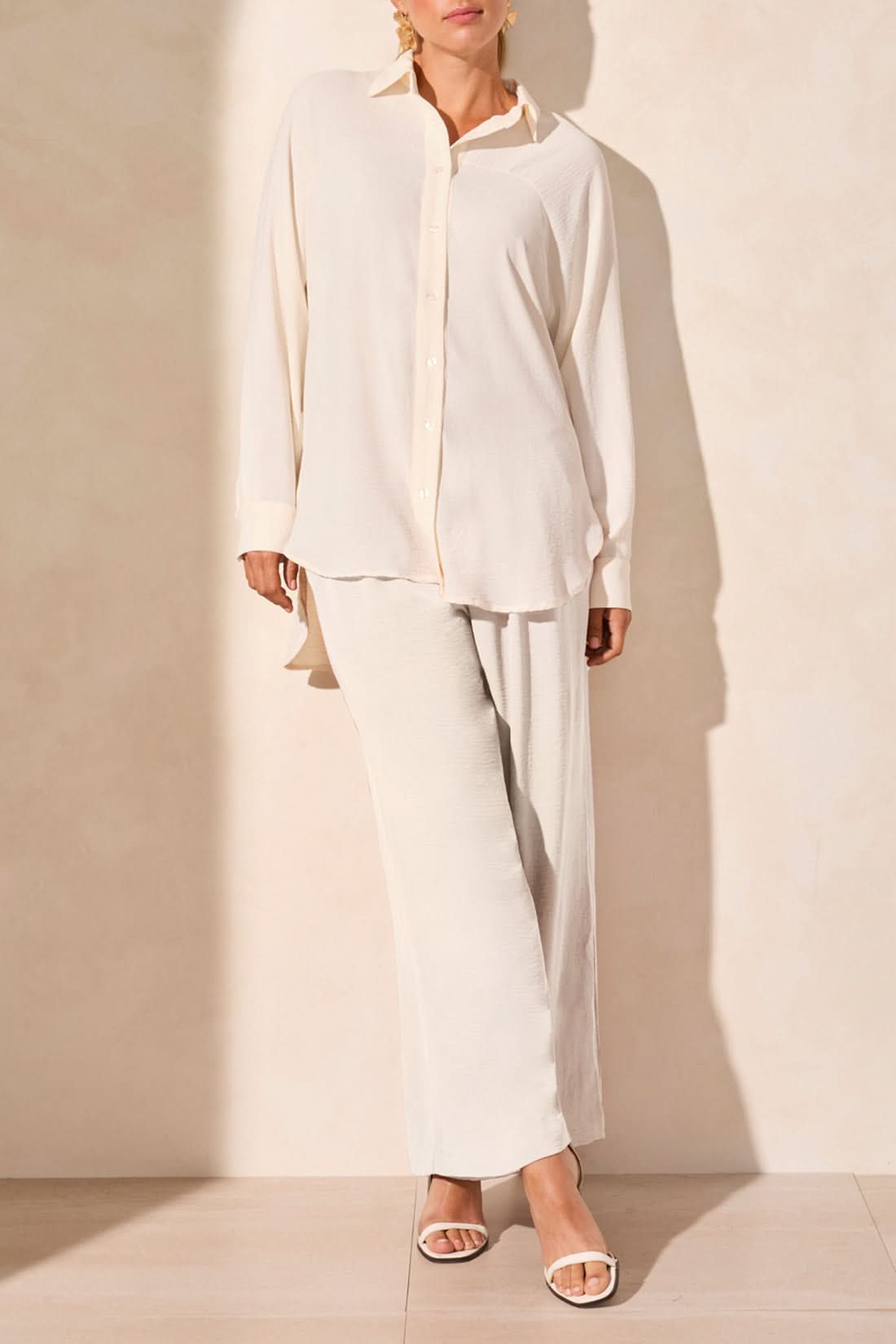 A person wearing the Tribal FLOWY RAGLAN SLEEVE SHIRT in brown, paired with loose-fitting pants, stands against a plain light-colored background.