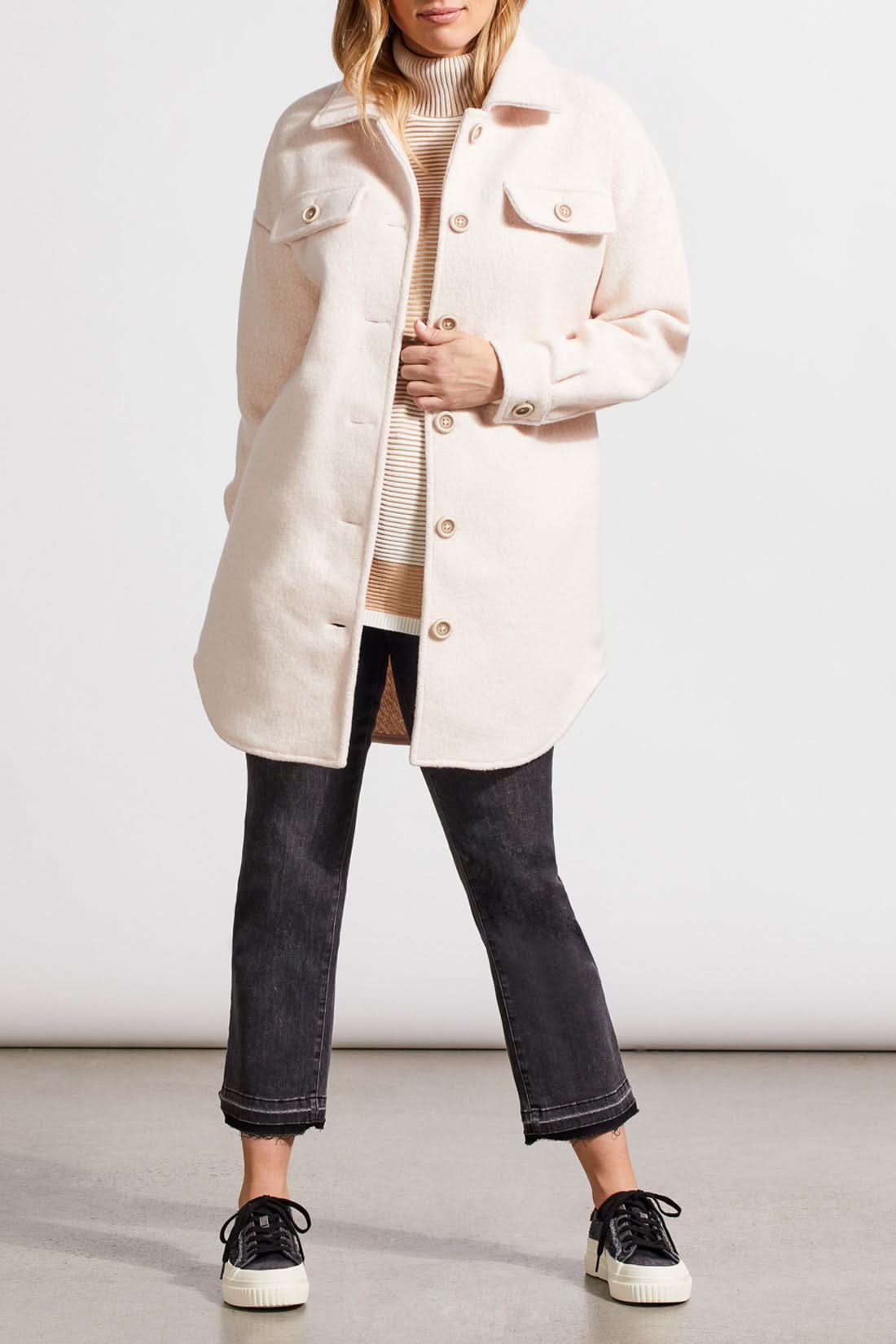 An individual with light hair is wearing a pale cream Stretch Boiled Wool Jacket by Tribal, featuring double-breasted button details. They are also dressed in a ribbed turtleneck sweater and are positioned against a plain background.