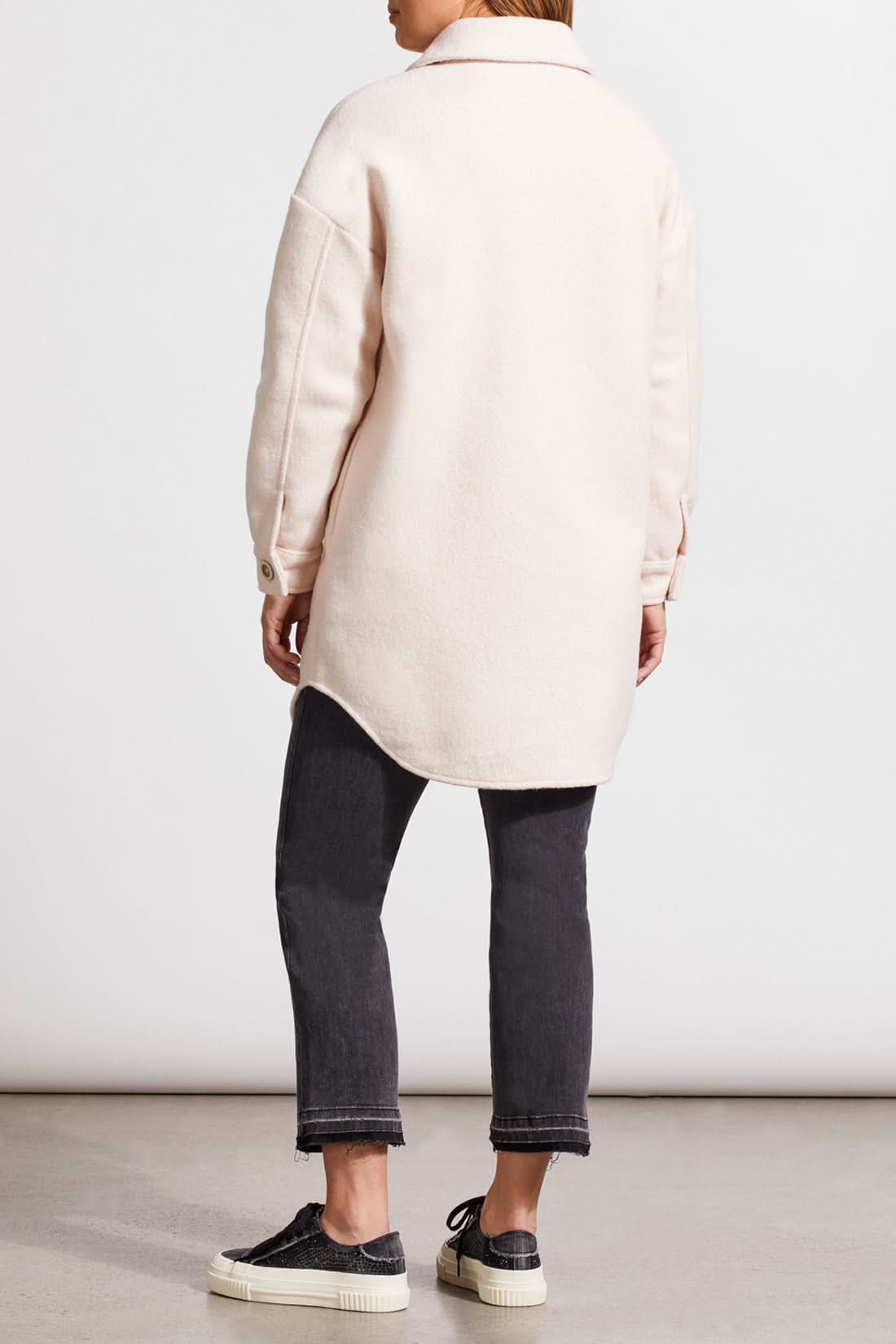 An individual with light hair is wearing a pale cream Stretch Boiled Wool Jacket by Tribal, featuring double-breasted button details. They are also dressed in a ribbed turtleneck sweater and are positioned against a plain background.