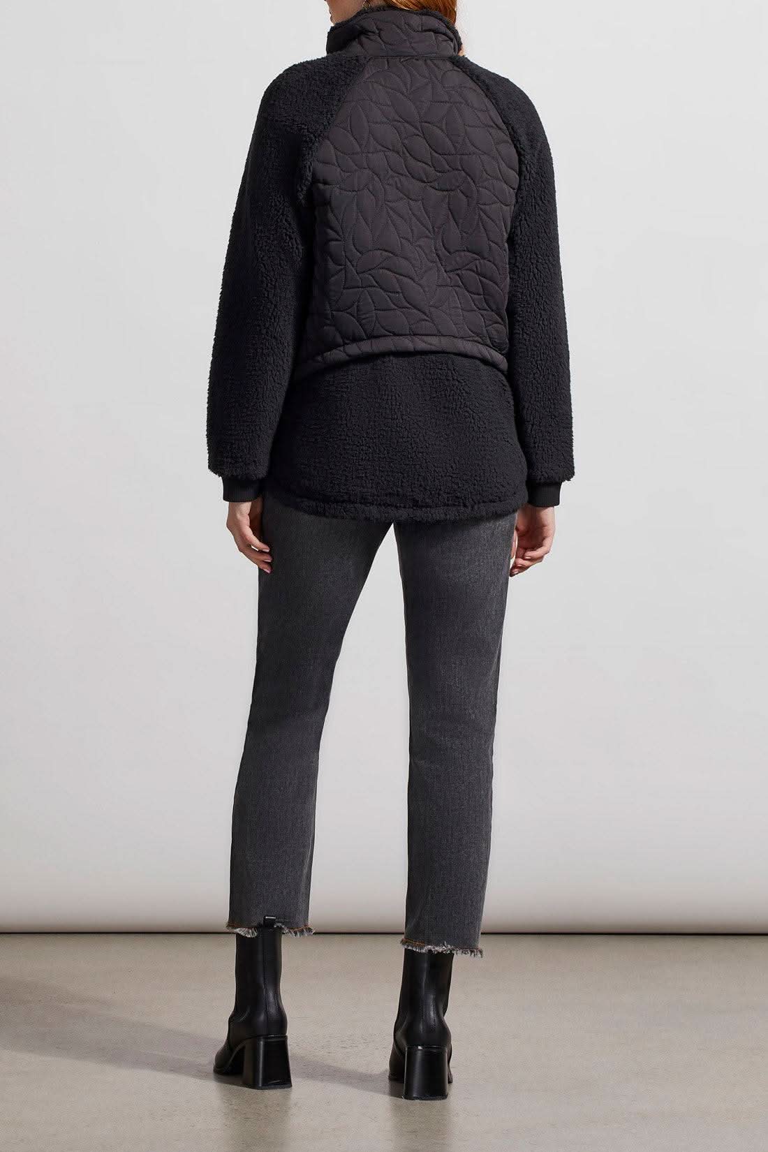 A woman wearing a Tribal Quilted Sherpa Jacket and jeans.